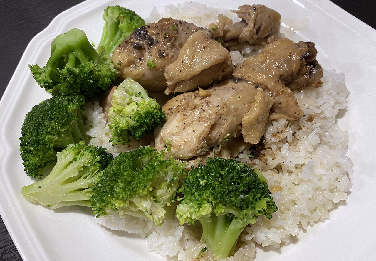 a plate of the filipino dish chicken adobo with sliced potatoes